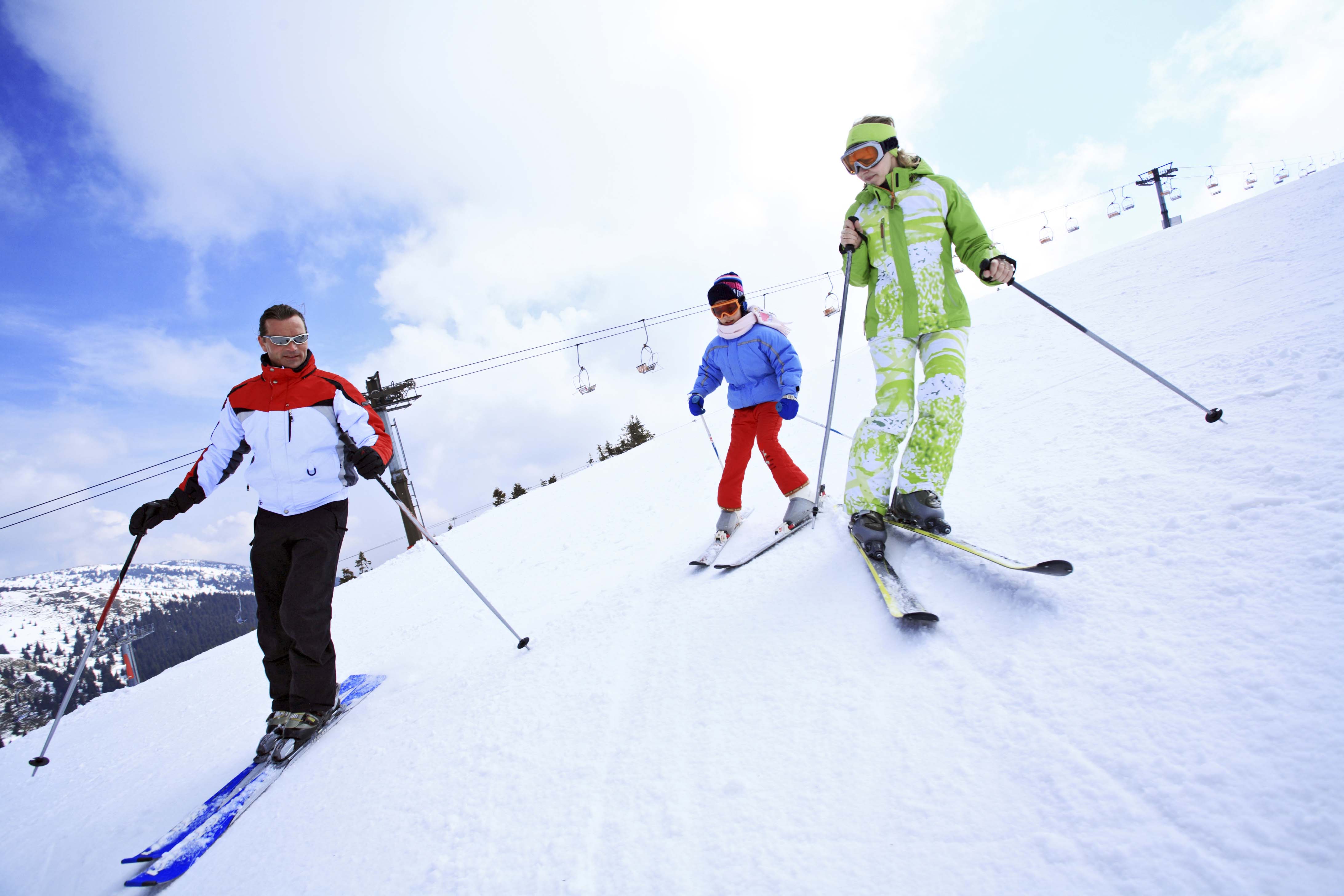 Семья лыжников. Катание на горных лыжах. На лыжах всей семьей. Лыжный курорт. Семья на горных лыжах.